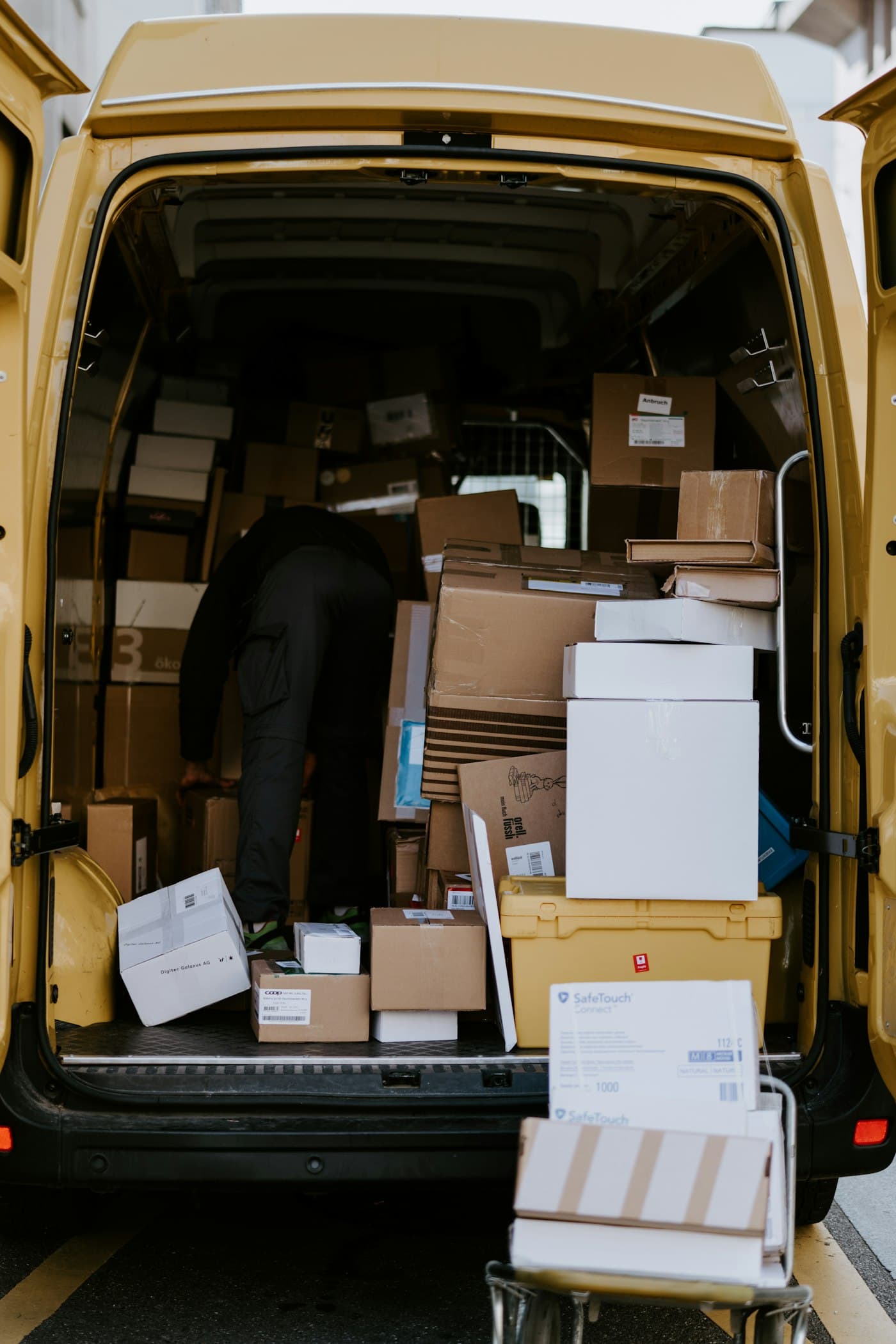 Courier loading parcels into a delivery van
